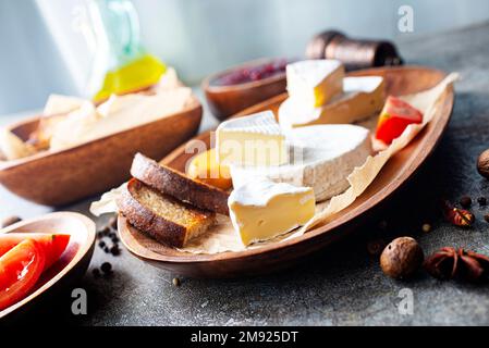 Camembert Käse mit Feigen, Himbeermarmelade. Rundbrie oder Camambert-Käse auf Schneidebrett Stockfoto