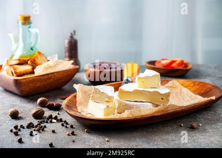 Camembert Käse mit Feigen, Himbeermarmelade. Rundbrie oder Camambert-Käse auf Schneidebrett Stockfoto