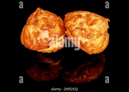 Zwei süße Chouquette, Nahaufnahme, isoliert auf Schwarz. Stockfoto