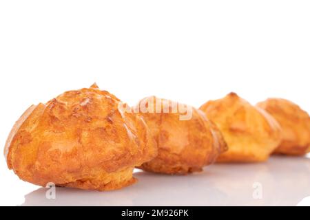 Mehrere frisch duftende Chouquettes auf weißem Hintergrund. Stockfoto