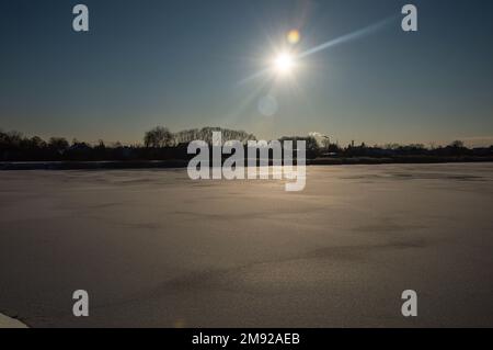 Winterlandschaft mit Sonne im Kontrast an kalten Tagen, Felder und Wälder. Stockfoto