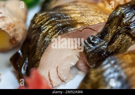 Scheiben geräucherter Fischmakrele oder scomber auf einem weißen Gericht mit Zitrone, Apfel, Ingwer, Gurke, Paprika, Grapefruit, Dill, Draufsicht. Makroaufnahme. Stockfoto