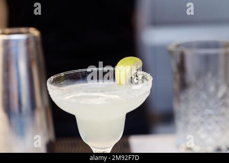 Der Prozess der Zubereitung eines rosa Cocktails mit Eis auf einem Bartisch. Hochwertiger Fotococktail Stockfoto