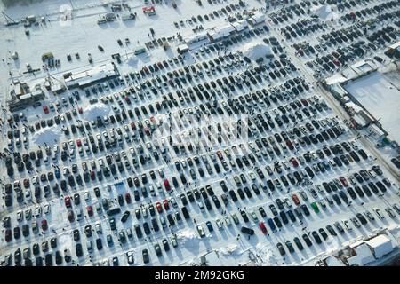 Luftaufnahme von vielen Autos zum Verkauf geparkt und Menschen Kunden zu Fuß auf dem Automarkt oder Parkplatz im Winter Stockfoto