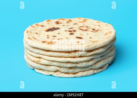 Ein Stapel indischer Flachbrote, minimalistisch auf einem blauen Tisch. Hausgemachtes Naan-Brot, asiatische traditionelle Küche. Stockfoto