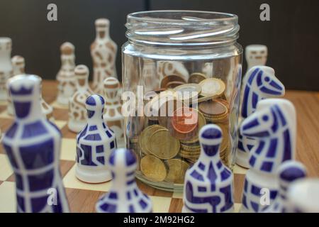 Euro-Ersparnisse in einem Glasglas unter Schachfiguren Stockfoto