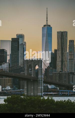 Hochhäuser in der Nähe der Brooklyn Bridge vor dem wolkenlosen Sonnenuntergang am Himmel in New York City Stockfoto