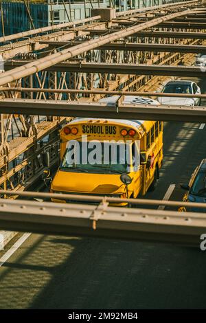 Von oben auf dem gelben Bus, der an sonnigen Tagen auf der Brooklyn Bridge in New York City fährt Stockfoto