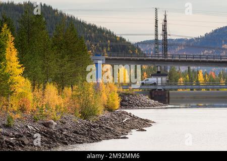 Reservoir mit Wasserkraftdamm und Strommasten im Stora-Sjöfallet-Nationalpark in Nordschweden Stockfoto