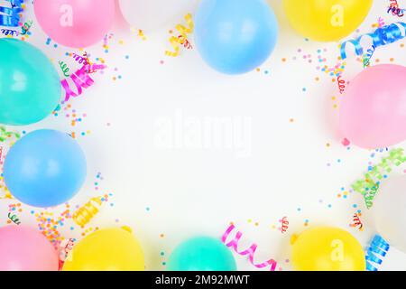Rahmen für Geburtstagsparty auf weißem Hintergrund. Blick von oben mit Ballons, Konfetti und Luftschlangen. Speicherplatz kopieren. Stockfoto