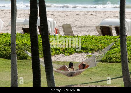 BIG ISLAND-HAWAII-17-06-2104. Ein Tourist liest ein Buch auf einer Hängematte am Kona Beach auf der großen Insel Hawaii. © JOSE ISAAC BULA URRUTIA. Stockfoto