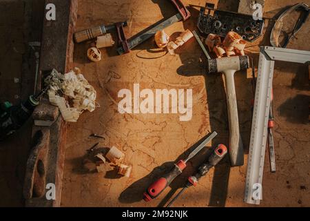 Von oben professionelle Werkzeuge und Instrumente auf Holztisch mit Sägespäne in der Werkstatt Stockfoto