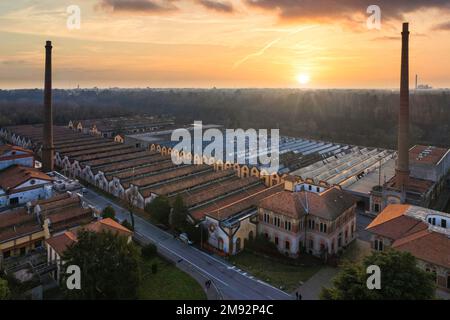 Blick aus der Vogelperspektive auf das historische Arbeiterdorf Crespi d'Adda bei Sonnenuntergang, Lombardei, Italien Stockfoto