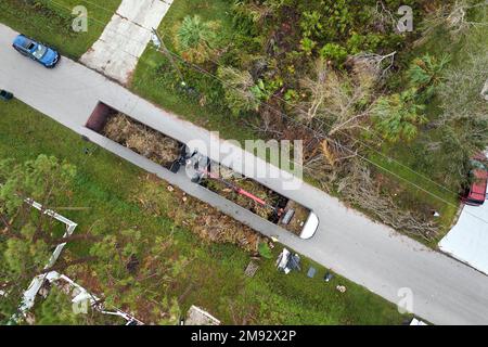 Draufsicht auf den besonderen Nachwirkungen des Unwehen-Rückgewinnungs-Muldenkipper des Unwrts, der Baumzweige aus ländlichen Straßen Floridas aufsammelt. Umgang mit Konsequenzen Stockfoto