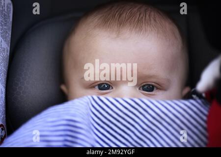 Ein drei Monate altes Baby, in eine Decke gewickelt. Stockfoto