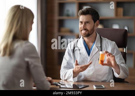 Lächelnder Arzt, Der Der Patientin Nach Der Untersuchung Medikamente Verschreibt Stockfoto
