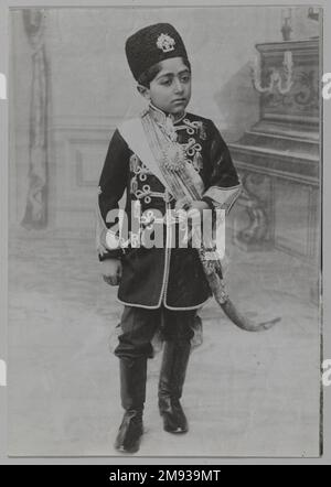 Porträt von Ahmad Shah als junger Junge, eines von 274 Vintage-Fotos, ca. 1890 oder 1900-1905. Foto: Gelatine Silver, 6 1/2 x 4 9/16 cm (16,5 x 11,6 cm). Der junge, frühe Junge, der auf diesem Foto von Sevruguin abgebildet ist, wurde vorläufig als Malijak Aziz al-Sultan identifiziert, historisch bekannt als passives Objekt von Nasir al-DIN Shahs Wunsch. Es wurde auch vermutet, dass er Ahmad Shah sein könnte, der letzte Herrscher der Qajar-Dynastie (r. 1909-1925). Unabhängig von der wahren Identität des Subjekts zeigt dieses Porträt Sevruguins Geschick, menschliche Persönlichkeiten zu erfassen und darzustellen Stockfoto