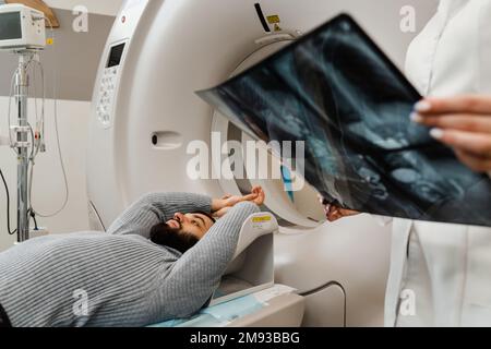 CT-Scan des Abdomens des Menschen in der medizinischen Klinik. Der Mann führt eine computertomographische Röntgenuntersuchung des Abdomens in einem CT-Scan-Raum durch Stockfoto