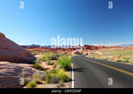 Eine Straße, die durch Sandsteinformationen im Valley of Fire State Park, Nevada, USA führt. Den amerikanischen Südwesten erkunden. Stockfoto