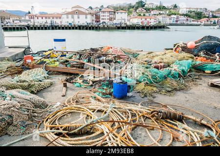 Töpfe, Netze und Fischerboote in einem kantabrischen Hafen. Stockfoto