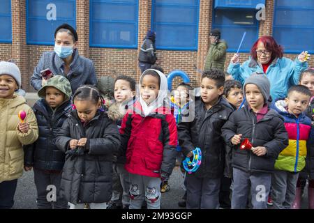 Lokale Schulkinder sehen sich die 2023 stattfindende Parade der Three Kings Day entlang der 3. Avenue in Spanish Harlem an, die von El Museo del Barrio, New Yorks führender lateinamerikanischer Kulturinstitution, ausgerichtet wird. Eine der großen künstlerischen Puppen des El Museo del Barrio, die jedes Jahr die Parade leiten. Stockfoto