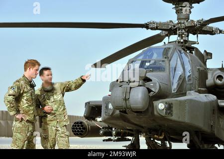 HINWEIS FÜR REDAKTEURE: Auf Antrag des Verteidigungsministeriums hat der Fotoschalter der PA die Gesichter der Dienstmädchen verschwommen, die auf diesen Bildern neben dem Herzog von Sussex erscheinen. Aktenfoto vom 07.09/12 von Prinz Harry, der von einem Mitglied seiner Staffel (Name nicht angegeben) die Apache-Fluglinie im Camp Bastion in Afghanistan gezeigt wird, von wo aus er während seiner Dienstreise als Kopilot des Schützen operieren wird. Ausgabedatum: Montag, 16. Januar 2023. Stockfoto