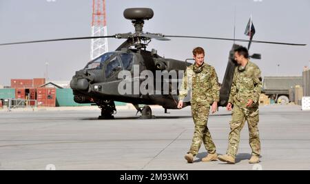 HINWEIS FÜR REDAKTEURE: Auf Antrag des Verteidigungsministeriums hat der Fotoschalter der PA die Gesichter der Dienstmädchen verschwommen, die auf diesen Bildern neben dem Herzog von Sussex erscheinen. Aktenfoto vom 07.09/12 von Prinz Harry, der von einem Mitglied seiner Staffel (Name nicht angegeben) die Apache-Fluglinie im Camp Bastion in Afghanistan gezeigt wird, von wo aus er während seiner Dienstreise als Kopilot des Schützen operieren wird. Ausgabedatum: Montag, 16. Januar 2023. Stockfoto