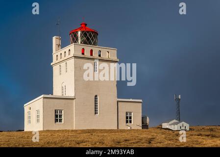 Der berühmte Leuchtturm auf der Halbinsel Dyrhólaey, Dyrhólaeyjarviti auf Isländisch, in wunderschönem Abendlicht vor einem tiefen blauen Himmel, Island, nahe Vík Stockfoto