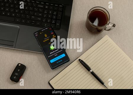 Mexiko, CDMX - 01. Mai 2022: Duolingo, eine Anwendung zum Englischlernen auf einem Handybildschirm auf einem Schreibtisch mit einem Notebook und einem Kaffee daneben. Stockfoto