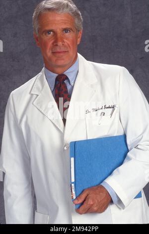 Nahaufnahme eines älteren männlichen Arztes in einem weißen Laborkittel mit Krankenakten Stockfoto