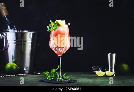 Französischer Orangenmuli, alkoholischer Cocktail mit Wodka, Limettensaft, Ingwerbier, Sirup, roter Orangensaft und Eiswürfel, garniert mit Minze. Dunkle Hintergrundebene Stockfoto