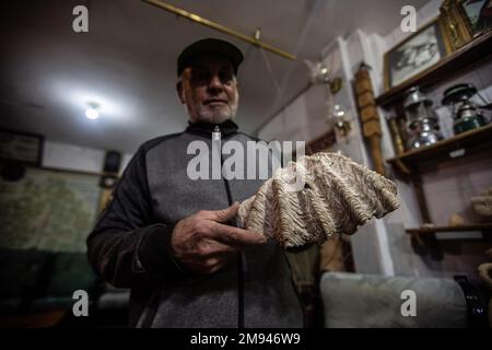 Palästinensischer Ramadan sammelt „Reichtum“ an Steinen und archäologischen Felsen in Gaza. Palästinensischer Ramadan Ahmed liebt es, in seinem kleinen Museum in seinem Haus in Khan Yunis, südlich des Gazastreifens, in die Tiefen der antiken Zivilisationen einzutauchen, wo er liebend gerne eine Gruppe kostbarer Artefakte erwirbt, darunter den jemenitischen Achatstein, den Sijil-Stein, der im Heiligen Koran erwähnt wird, Kristalle und transparente Steine, der berühmte Fingerabdruckstein und der Mondmeteoritenstein, einer der seltensten Arten der Welt, Steine, die mit seltsamen Formen aus der Antike bemalt sind. Stockfoto