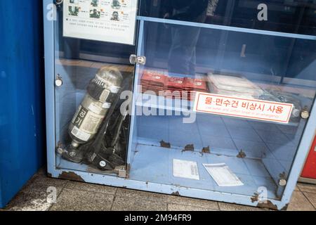 Seoul, Korea. 21. Dezember 2022. Ein „Relief Goods Storage“-Schrank mit Gasmasken, Rationen und SCBA-Löschausrüstung für die Katastrophenvorsorge an der U-Bahn-Linie 2 in Seoul am Bahnhof Hapjeong. Die U-Bahn-Stationen in Seoul verfügen über große unterirdische Anlagen, die auch als Notunterkünfte dienen, da sich die Stadt in Artillerienreichweite der nordkoreanischen Regierung der DVRK befindet.die Linie 2 der Seoul Metropolitan Subway, auch bekannt als Grüne Linie, verläuft Ost-West durch die Stadt und verbindet wichtige Bezirke wie Gangnam, Rathaus und Shinchon. Es handelt sich um eine der belebtesten Strecken im System und ist bekannt für Stockfoto