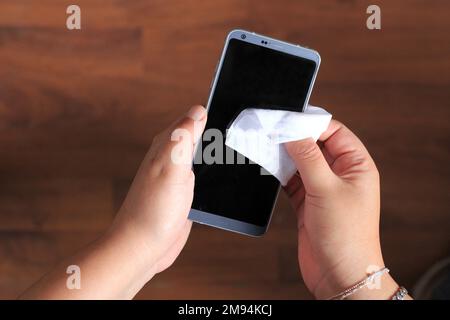 Hygiene zu Hause, Handy mit einem antibakteriellen Wischtuch reinigen und desinfizieren, Virenschutz Stockfoto