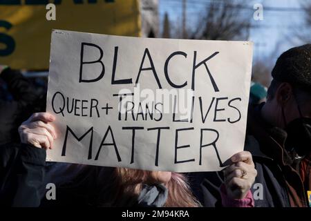 Seattle, Washington, USA. 16. Januar 2023. Ein Teilnehmer hält ein Schild zur Unterstützung von Schwarzen, Schwulen und Transen während eines marsches durch Seattles Central District, um das Leben und Werk von Martin Luther King Jr. zu feiern Dieses Jahr ist der Seattle MLK Jr. Organisation der 40.-jährigen Ehrung des Erbes von Dr. Kings durch die Koalition. Kredit: Paul Christian Gordon/Alamy Live News Stockfoto
