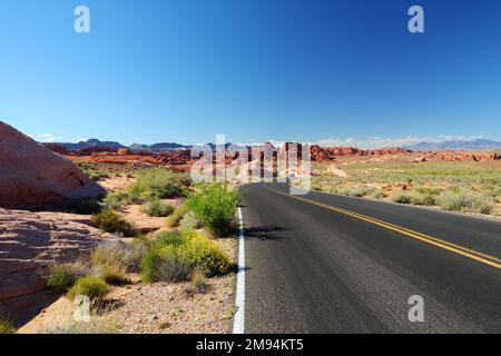 Eine Straße, die durch Sandsteinformationen im Valley of Fire State Park, Nevada, USA führt. Den amerikanischen Südwesten erkunden. Stockfoto