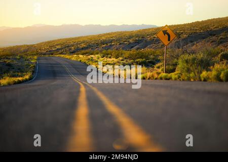 Eine Straße, die durch Sandsteinformationen im Valley of Fire State Park, Nevada, USA führt. Den amerikanischen Südwesten erkunden. Stockfoto