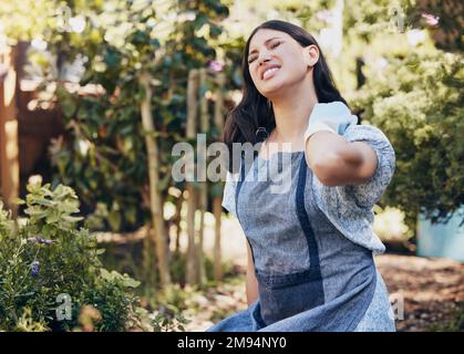 Es ist nicht der Stress, der uns tötet, seine Reaktion darauf. Eine junge Floristin mit Nackenschmerzen bei der Arbeit. Stockfoto