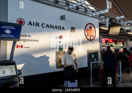 Toronto, Kanada. 16. Januar 2023. Ein maskierter Mann mit Gepäck wartet am Schalter von Air Canada am YYZ Toronto Pearson International Airport. Die kanadische Reise war im letzten Winter mit einer Reihe von Störungen konfrontiert, die sowohl von Passagieren als auch von der Regierung kritisiert wurden. Die Anhörungen des Transportkomitees begannen herauszufinden, warum die Reisesaison in diesem Jahr für viele Reisende in Chaos versinkt. (Foto: Katherine Cheng/SOPA Images/Sipa USA) Guthaben: SIPA USA/Alamy Live News Stockfoto