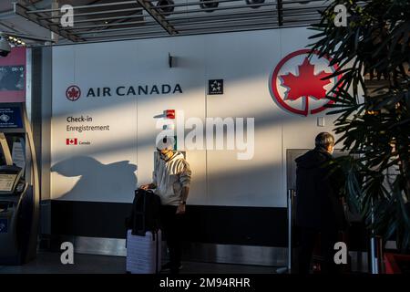 Toronto, Kanada. 16. Januar 2023. Ein maskierter Mann mit Gepäck wartet am Schalter von Air Canada am YYZ Toronto Pearson International Airport. Die kanadische Reise war im letzten Winter mit einer Reihe von Störungen konfrontiert, die sowohl von Passagieren als auch von der Regierung kritisiert wurden. Die Anhörungen des Transportkomitees begannen herauszufinden, warum die Reisesaison in diesem Jahr für viele Reisende in Chaos versinkt. (Foto: Katherine Cheng/SOPA Images/Sipa USA) Guthaben: SIPA USA/Alamy Live News Stockfoto