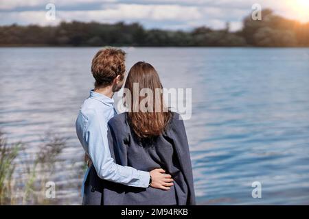 Das verliebte Paar quatscht am Ufer des Sees. Stockfoto