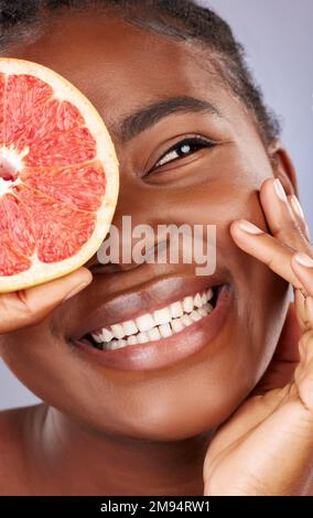 Es hat einige ziemlich robuste Vorteile für die Hautpflege. Studioaufnahme einer schönen jungen Frau mit halbierter Grapefruit. Stockfoto