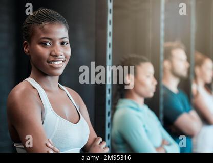 Das ist der richtige Ort. Eine selbstbewusste junge Frau im Fitnessstudio. Stockfoto