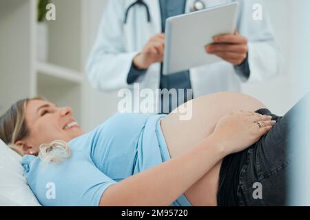 .Ein Arzt während einer Konsultation mit einer Schwangeren in einer Klinik. Stockfoto