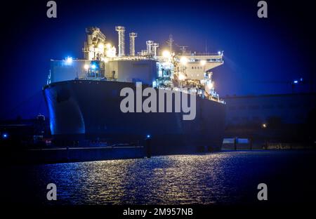 Lubmin, Deutschland. 14. Januar 2023. Das Verarbeitungsschiff „Neptune“ wird am Abend am LNG-Terminal im Industriehafen festgemacht. Das an der Ostsee gelegene Terminal für die Lieferung von Flüssigerdgas (LNG) wird offiziell in Betrieb genommen und erhält die letzte ausstehende Betriebsgenehmigung. Deutschland verlässt sich unter anderem auf von Schiffen geliefertes LNG, um die versagten russischen Gaslieferungen zu ersetzen. Durch die Interaktion mehrerer Schiffe sollen jährlich bis zu 5,2 Milliarden Kubikmeter Erdgas in die Lubmin-Pipeline eingespeist werden können. Kredit: Jens Büttner/d/dpa/Alamy Live News Stockfoto