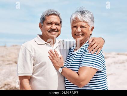 So verbringen wir unsere Sonntage. Ein Seniorenpaar, das am Strand zusammenstand. Stockfoto