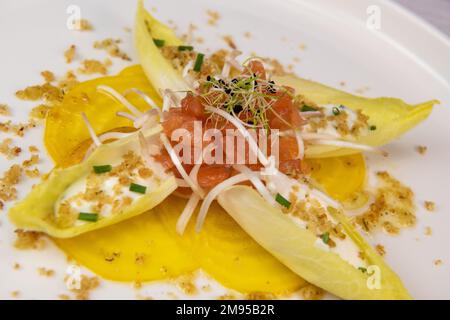 Rezept für Lachs-Gravlax-Salat, Endivien mit frischer Sahne, Schnittlauch, gelbe chioggia-Rote Beete und Lauch-Triebe Stockfoto