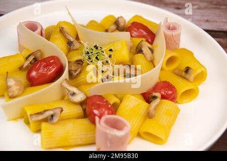 Rezept für Rigatoni Pasta mit Chiatsu Squash Cream, Schinken, Tomaten, Pilzen und Parmesan Stockfoto