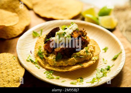 Vegetarische Tostadas mit Hummus. Tostada, Name für verschiedene Gerichte in Mexiko, darunter eine getoastete Tortilla als Hauptbasis für die Zubereitung Stockfoto