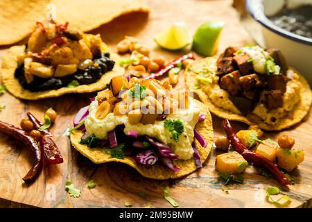 Vegetarische Tostadas mit Hummus. Tostada, Name für verschiedene Gerichte in Mexiko, darunter eine getoastete Tortilla als Hauptbasis für die Zubereitung Stockfoto